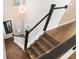 Wooden staircase with white banisters and black handrail, illuminated by a modern chandelier at 896 Tilden Oaks Trl, Winter Garden, FL 34787