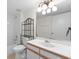 Bathroom featuring white cabinets, single sink, decorative shelving, and shower-tub combo at 923 Lexington Pkwy # 14, Apopka, FL 32712