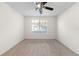 Carpeted bedroom featuring a ceiling fan and large window with a view at 923 Lexington Pkwy # 14, Apopka, FL 32712