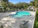 Community pool featuring a white fence, lounge chairs and lush landscaping at 923 Lexington Pkwy # 14, Apopka, FL 32712