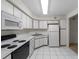 Functional kitchen with white cabinetry, black appliances, and tile flooring at 923 Lexington Pkwy # 14, Apopka, FL 32712