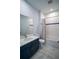 The bathroom features marble floors, a blue vanity, and a shower-tub combo with white tile at 1114 Turquoise Waves Cv, Kissimmee, FL 34747