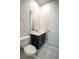 A bathroom with a toilet, white countertop, brushed gold hardware, and large mirror at 1114 Turquoise Waves Cv, Kissimmee, FL 34747