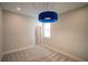 Cozy bedroom with neutral carpet, a modern light fixture, and a window providing natural light at 1114 Turquoise Waves Cv, Kissimmee, FL 34747