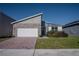 Charming single Gathering home with brick driveway, modern architectural details, and neatly manicured landscaping at 1114 Turquoise Waves Cv, Kissimmee, FL 34747