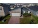 Single Gathering home featuring a paved driveway, attached garage, and well-maintained front lawn in a residential area at 1114 Turquoise Waves Cv, Kissimmee, FL 34747