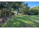 Expansive backyard featuring a play set and trampoline surrounded by mature trees at 1384 E Lake Shore Blvd, Kissimmee, FL 34744