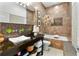View of the bathroom with dark vanity, white basin sink, mosaic tile and soaking tub at 1384 E Lake Shore Blvd, Kissimmee, FL 34744