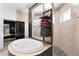 Bright bathroom features a soaking tub, step-in shower and a modern shelving unit at 1384 E Lake Shore Blvd, Kissimmee, FL 34744