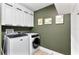 Modern laundry room with front loading washer and dryer and white upper cabinets at 1384 E Lake Shore Blvd, Kissimmee, FL 34744
