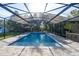 Stunning screened-in pool with inviting blue water and an elegant paved deck, surrounded by lush greenery and mature trees at 1384 E Lake Shore Blvd, Kissimmee, FL 34744