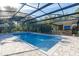 Enclosed swimming pool with outdoor kitchen, fireplace, and tv, surrounded by lush greenery and mature trees at 1384 E Lake Shore Blvd, Kissimmee, FL 34744