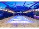 Twilight view of the screened-in pool with clear blue water and string lights creating a magical nighttime ambiance at 1384 E Lake Shore Blvd, Kissimmee, FL 34744