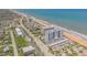 An aerial view of a beachfront condo building and a vibrant coastline at 1415 Ocean Shore Blvd # 704, Ormond Beach, FL 32176