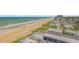 An aerial view showcasing the beachfront property next to a large, sandy beach at 1415 Ocean Shore Blvd # 704, Ormond Beach, FL 32176