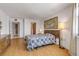 Bright bedroom with a bed with a colorful quilt, wooden floor, a window and dresser at 1415 Ocean Shore Blvd # 704, Ormond Beach, FL 32176