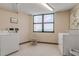 Bright laundry room with washer, dryer, tiled floors, and a window at 1415 Ocean Shore Blvd # 704, Ormond Beach, FL 32176