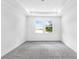 Bright bedroom featuring two windows, neutral carpet, and tray ceiling detail at 15491 Lebeau Loop, Winter Garden, FL 34787
