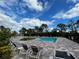Community pool and lounge chairs with palm trees at 15491 Lebeau Loop, Winter Garden, FL 34787