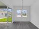 Dining room with modern light fixture and view of back yard through sliding glass door at 15491 Lebeau Loop, Winter Garden, FL 34787