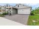Single-story home with a two-car garage and a brick-paved driveway complemented by well-maintained landscaping at 15491 Lebeau Loop, Winter Garden, FL 34787