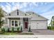 Charming single-story home featuring a red front door, a two-car garage, and meticulously landscaped front yard at 15491 Lebeau Loop, Winter Garden, FL 34787