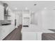 Modern kitchen featuring white cabinets, stainless appliances, large center island, and hardwood flooring at 15491 Lebeau Loop, Winter Garden, FL 34787