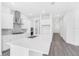 Modern kitchen featuring white cabinets, stainless appliances, large center island, and hardwood flooring at 15491 Lebeau Loop, Winter Garden, FL 34787
