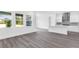 Open-concept living area with hardwood floors flowing into a bright, white kitchen featuring a kitchen island at 15491 Lebeau Loop, Winter Garden, FL 34787