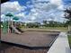 Community playground with green accents and a beautiful open field at 15491 Lebeau Loop, Winter Garden, FL 34787