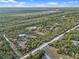 Aerial view showing homes nestled within a tree-filled neighborhood near a lake and train tracks at 1650 Cypress Ave, Orange City, FL 32763