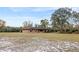 Expansive lawn surrounds this brick home with mature shade trees on a sunny day at 1650 Cypress Ave, Orange City, FL 32763