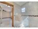 Bright bathroom with glass shower door, neutral tile and wood frame entrance to a bedroom at 1775 Druliner Rd, St Cloud, FL 34771