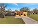 Charming yellow single-story home featuring a red tiled roof, gravel driveway, and screened in pool at 1775 Druliner Rd, St Cloud, FL 34771
