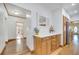 Hallway view of the kitchen featuring wood floors, white walls, and natural wood cabinets at 1775 Druliner Rd, St Cloud, FL 34771