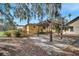 Backyard stone patio with pergola, mature trees, and view of the house's covered patio at 1775 Druliner Rd, St Cloud, FL 34771