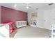 bedroom with light mauve accent wall, crib, and toy shelves at 2564 Bullion Loop, Sanford, FL 32771