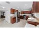 Bright kitchen featuring stainless steel appliances, dark wood cabinetry, and tiled floors with an adjacent living area at 2564 Bullion Loop, Sanford, FL 32771