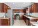 A kitchen showcasing stainless steel appliances, wood cabinets, and neutral countertops, creating a functional cooking space at 2564 Bullion Loop, Sanford, FL 32771