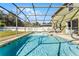 Screened-in pool area with a pristine pool, a hot tub, and the home in the background at 2564 Bullion Loop, Sanford, FL 32771