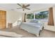 Inviting bedroom with ceiling fan, carpet, and a large window showcasing the exterior at 3100 Nancy St, Orlando, FL 32806