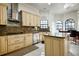 Well-lit kitchen featuring light wood cabinets, granite countertops, and stainless-steel appliances at 4178 S Chickasaw Trl, Orlando, FL 32829