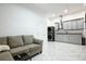 Modern living space with a gray sofa, stainless steel washer and dryer and gray kitchen cabinets with granite countertops at 4178 S Chickasaw Trl, Orlando, FL 32829