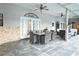 Covered outdoor patio with stone floors, exposed brick, dining set, ceiling fans and multiple seating options at 4178 S Chickasaw Trl, Orlando, FL 32829