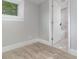 Bedroom featuring wood-look flooring, a window with natural light, and an access door to the bathroom at 4242 Raleigh St, Orlando, FL 32811