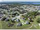 An aerial view of a residential area with multiple houses surrounded by greenery and a lake in the background at 429 Ohio Way, Kissimmee, FL 34759