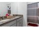 Bathroom with double sinks, granite countertop, and shower with striped curtain at 429 Ohio Way, Kissimmee, FL 34759
