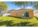 A spacious backyard with healthy green grass, patio, and a sliding glass door at 4605 Kalispell Rd, Kissimmee, FL 34758