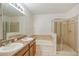 Elegant bathroom with dual sinks, bathtub, and separate glass-enclosed shower at 4605 Kalispell Rd, Kissimmee, FL 34758