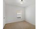 This is a cozy bedroom with neutral carpet, white walls, and a window letting in natural light at 4605 Kalispell Rd, Kissimmee, FL 34758